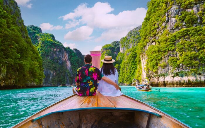 Couple,In,Front,Of,Longtail,Boat,At,The,Lagoon,Of