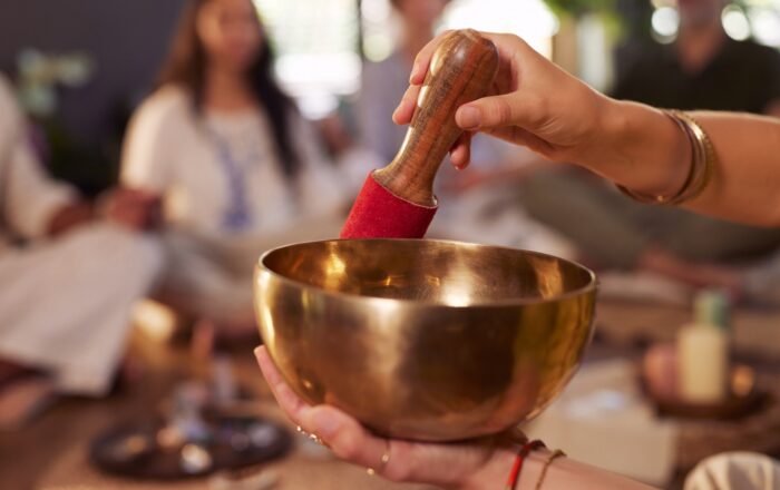 Close,Up,Of,Womans,Hand,Playing,Singing,Bowl,During,Group
